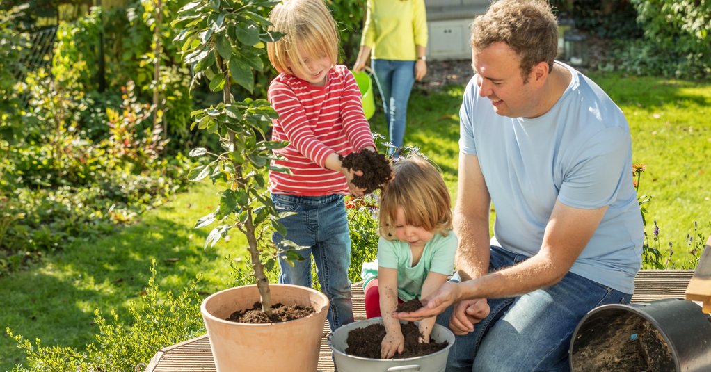 Familie pflanzt einen Obstbaum