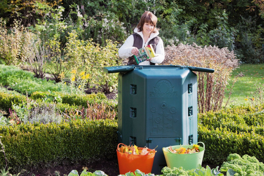 Komposter mit Gartenabfällen im Gemüsegarten wird mit Radivit Kompost-Beschleuniger geimpft